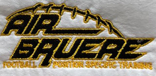 Black and yellow air bruere logo custom embroidered onto a white shirt.