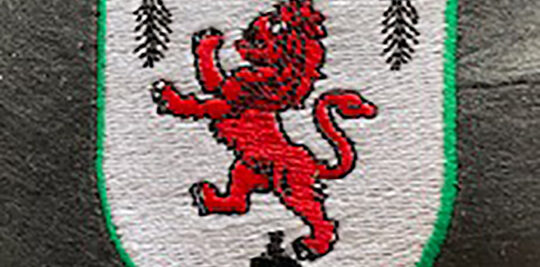 Red rampant lion Scottish flag custom embroidered onto a gray shirt.