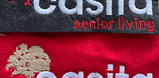 Casita senior living logo custom embroidered onto a gray shirt and a red shirt.